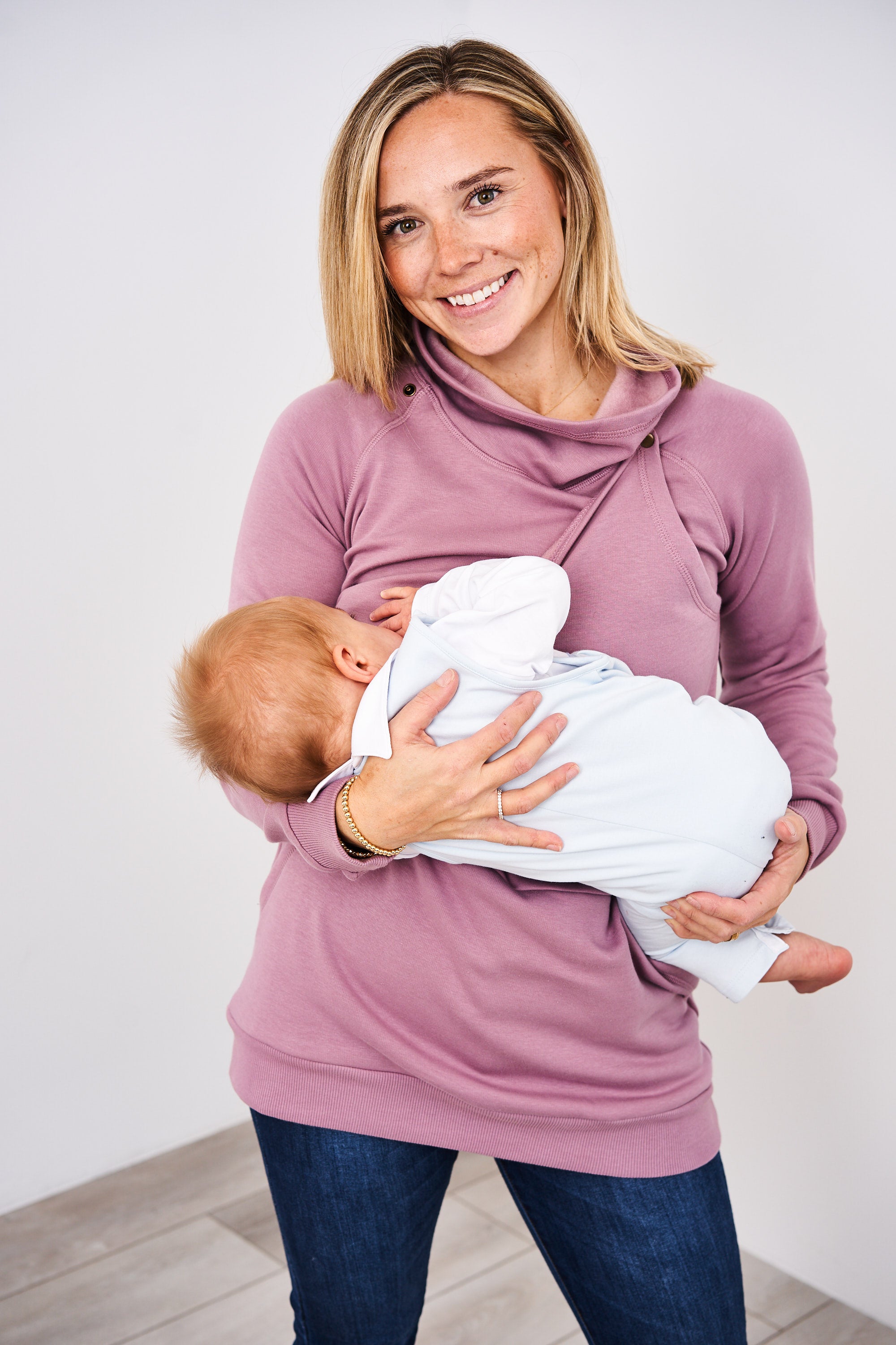 Woman breastfeeding an infant in the Lavender Latched Mama Harbor Snap Nursing Pullover
