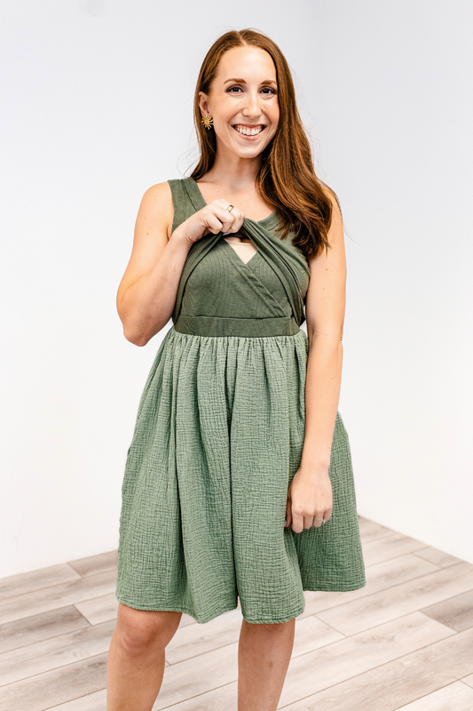 Woman showing the lift-up v-neck nursing access on the Latched Mama Breezy Cotton nursing dress in green.