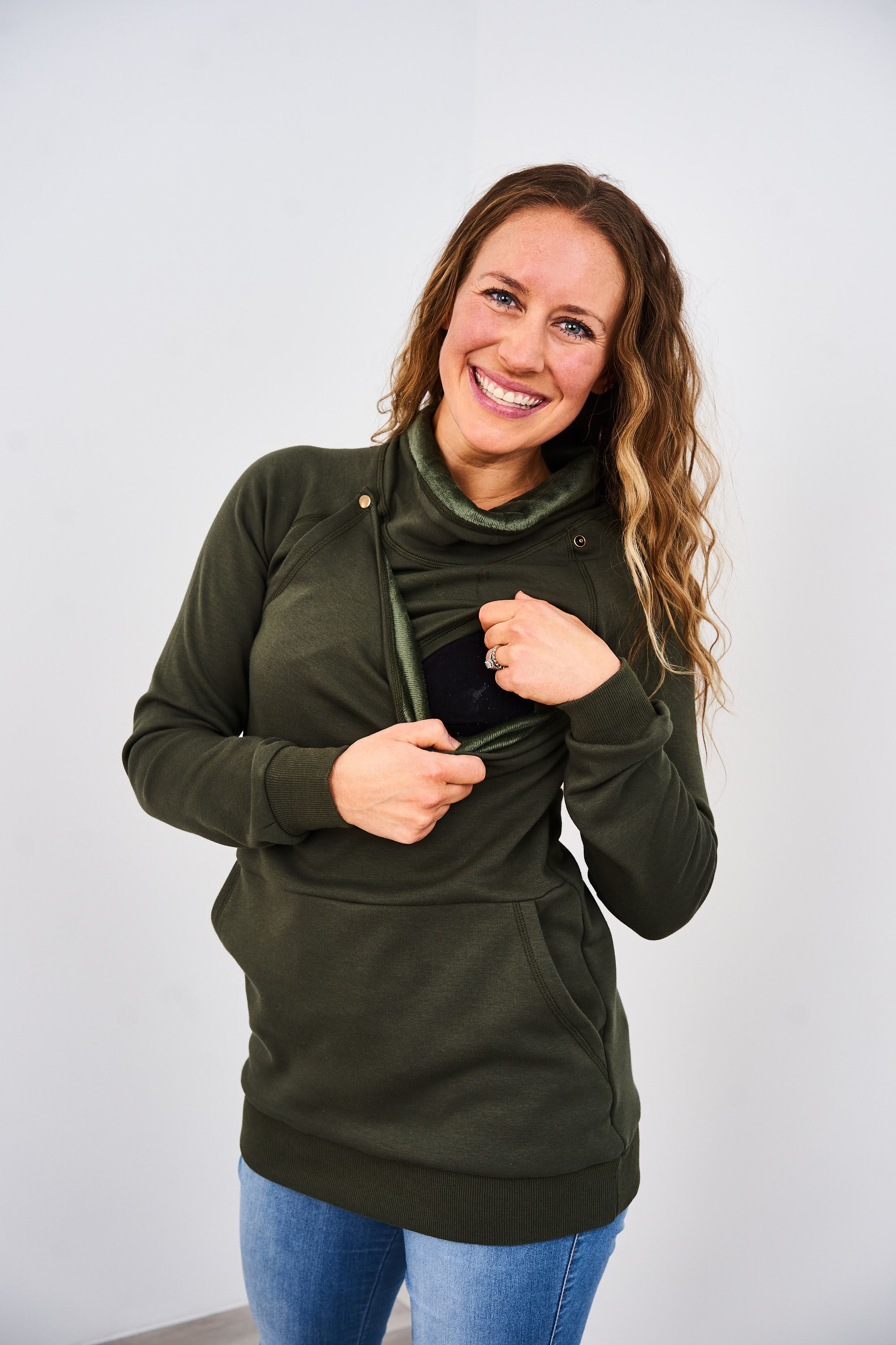 Woman showing the snap nursing access on the Latched Mama Green Harbor Snap Nursing Pullover against a white background