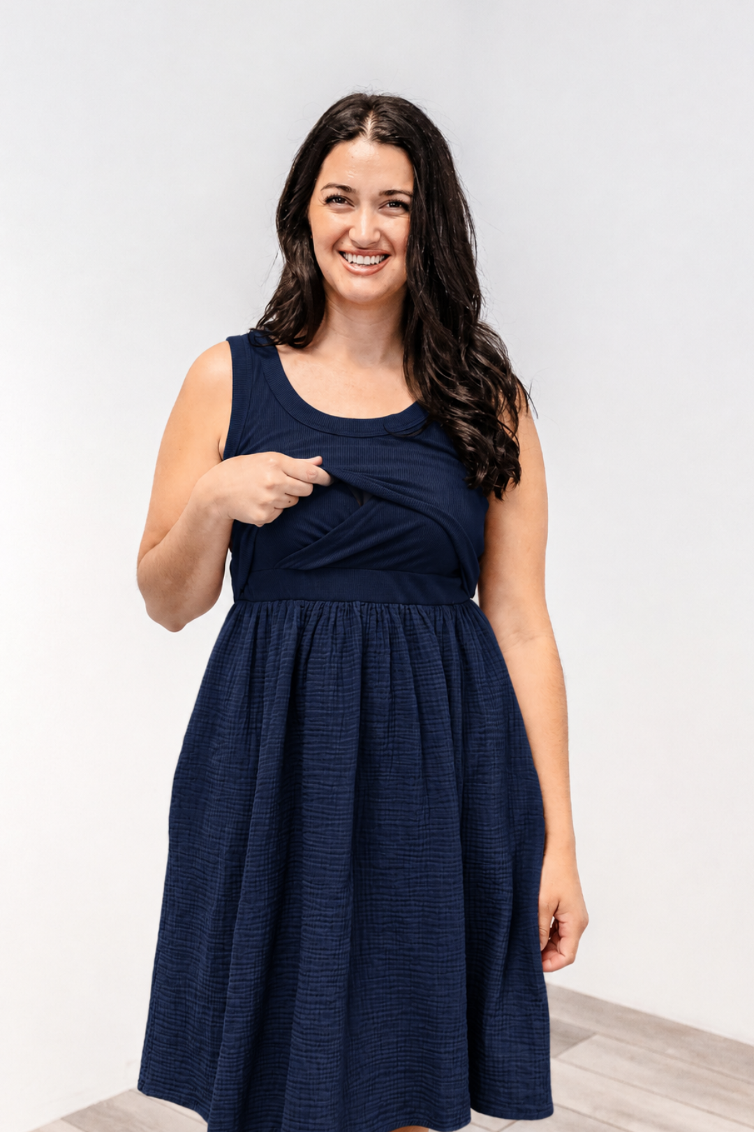 A woman showing the lift-up v-neck front nursing access on the Latched Mama Breezy Nursing Dress.