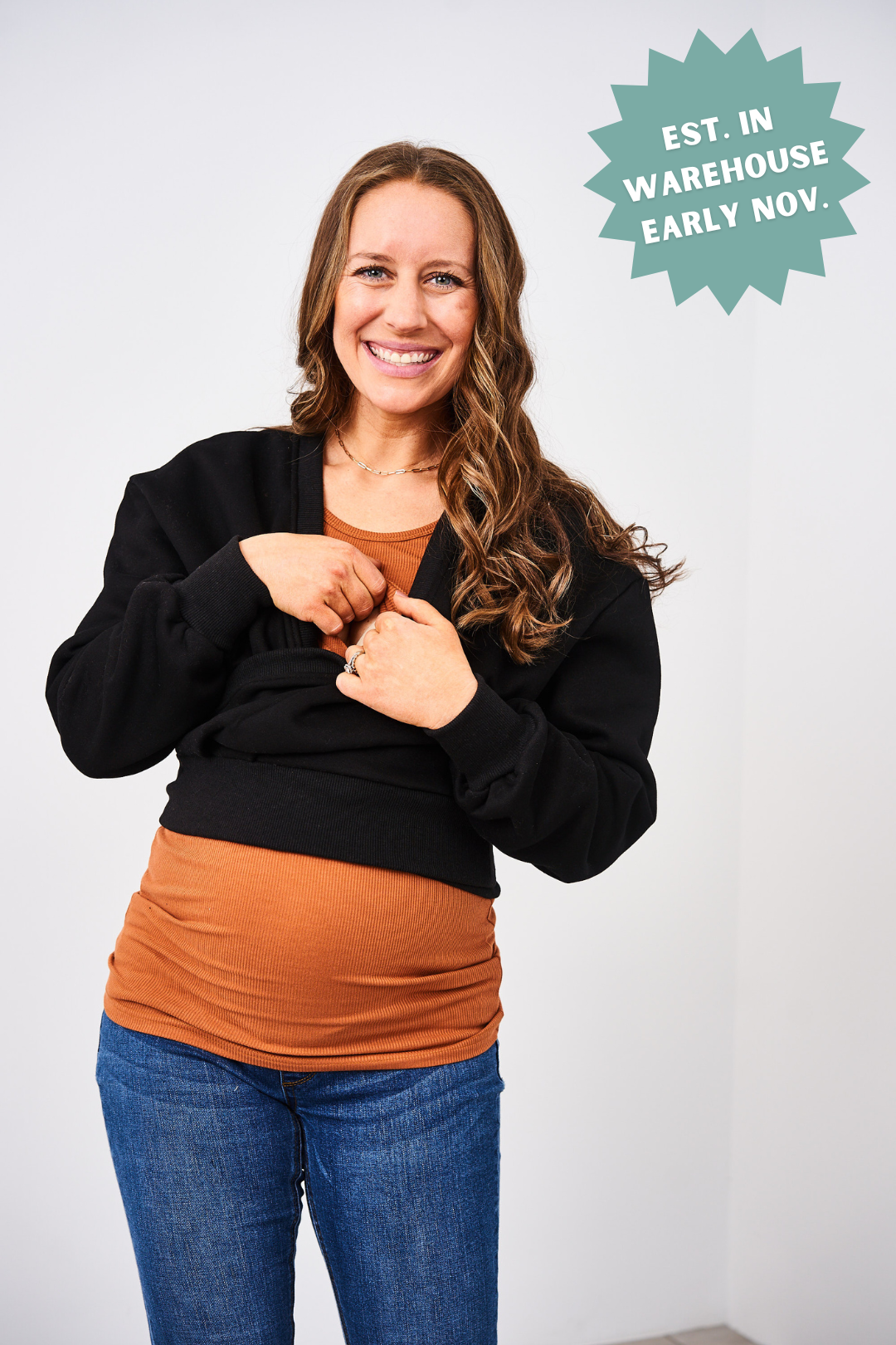 Woman wearing a black jacket over an orange shirt with text about warehouse early Nov.