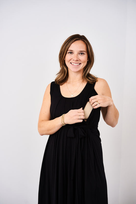 woman showing the side nursing access on the latched mama nursing romper in black.