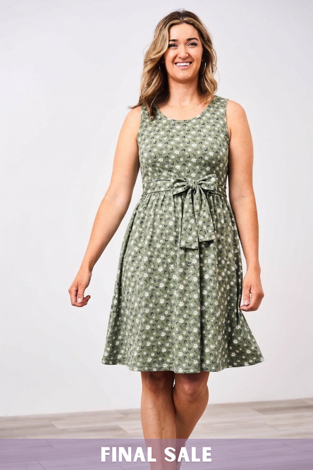 Woman wearing a green patterned floral Latched Mama nursing dress against a white background