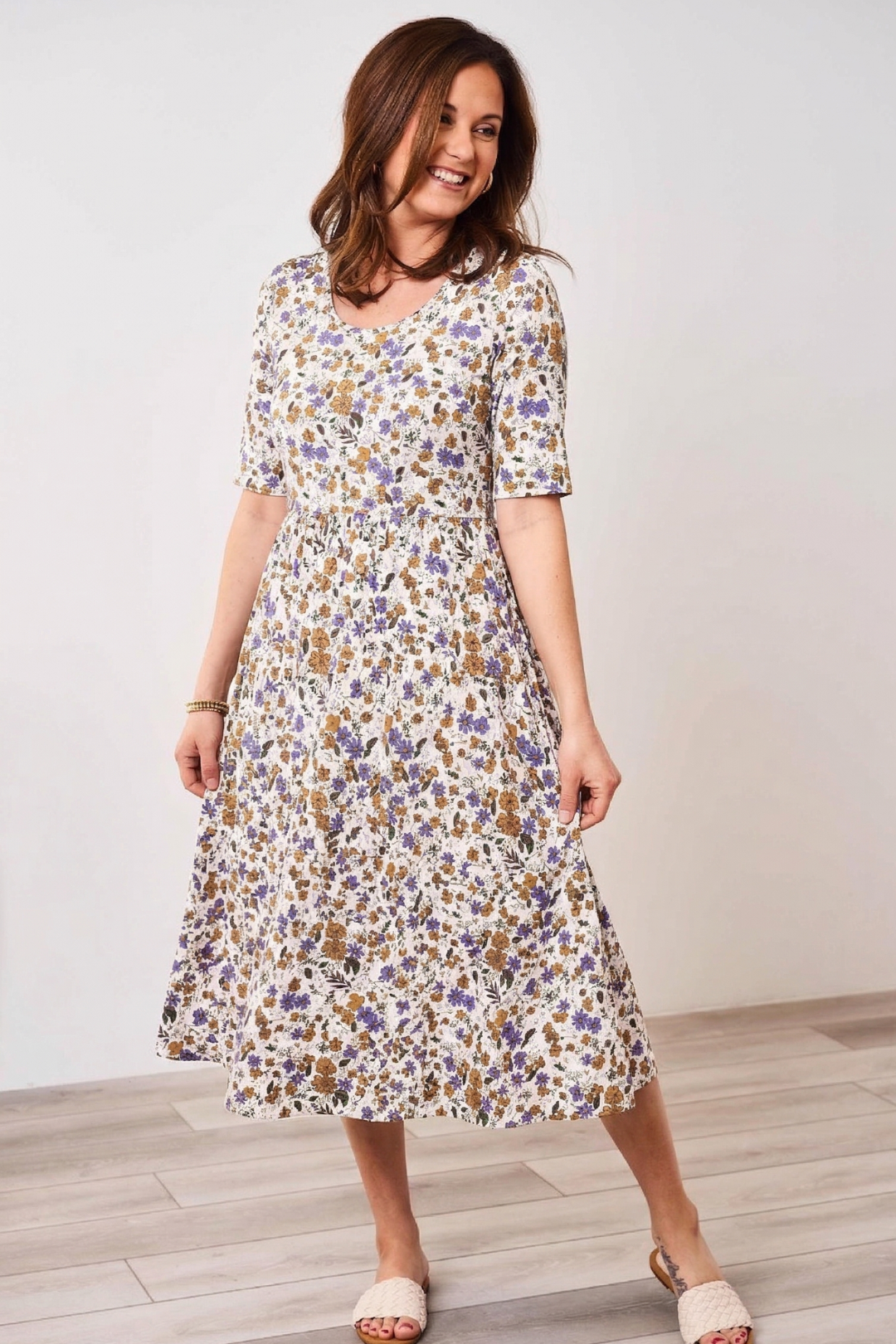 Woman wearing a floral Latched Mama nursing dress against a white background