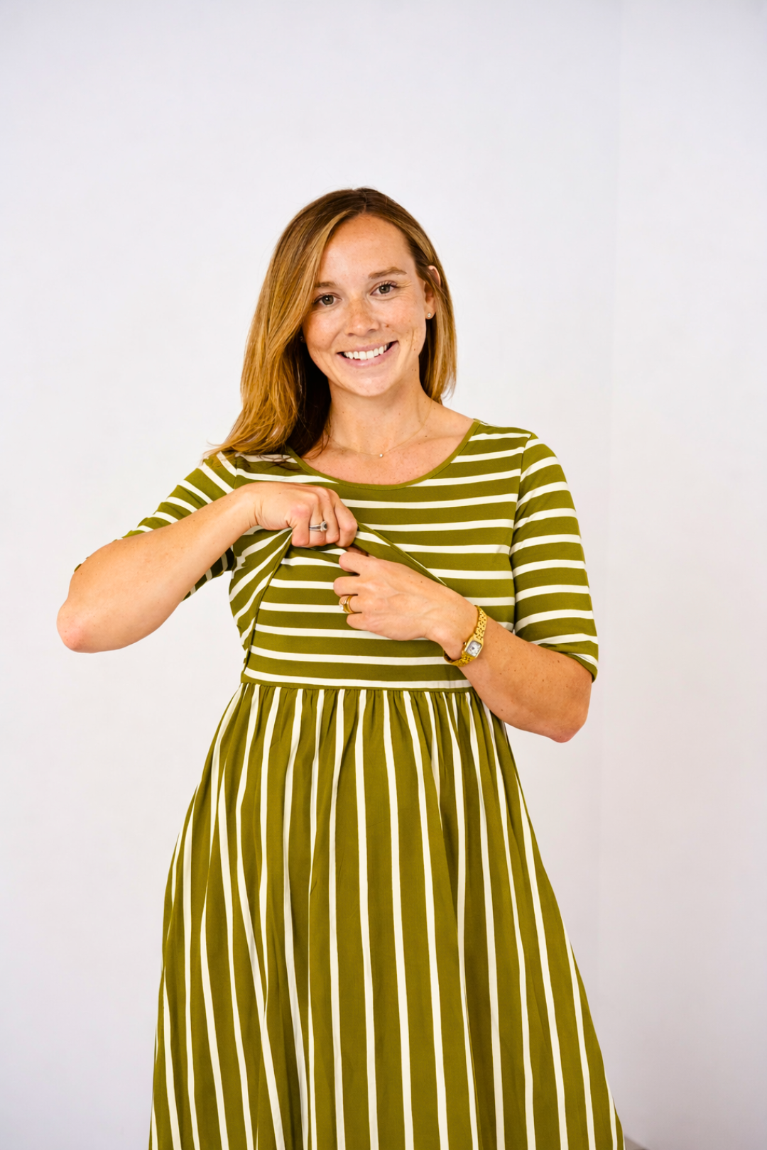 Woman wearing a green and white striped Latched Mama nursing dress against a white background