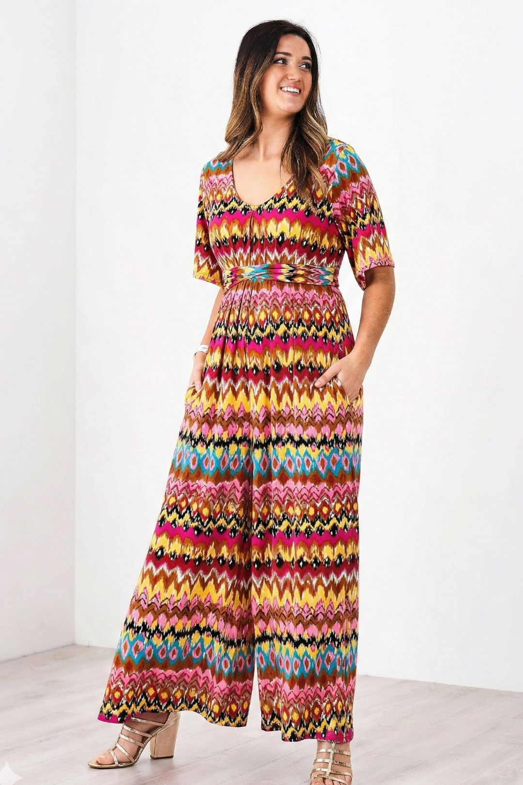 Woman wearing a colorful patterned romper on a white background