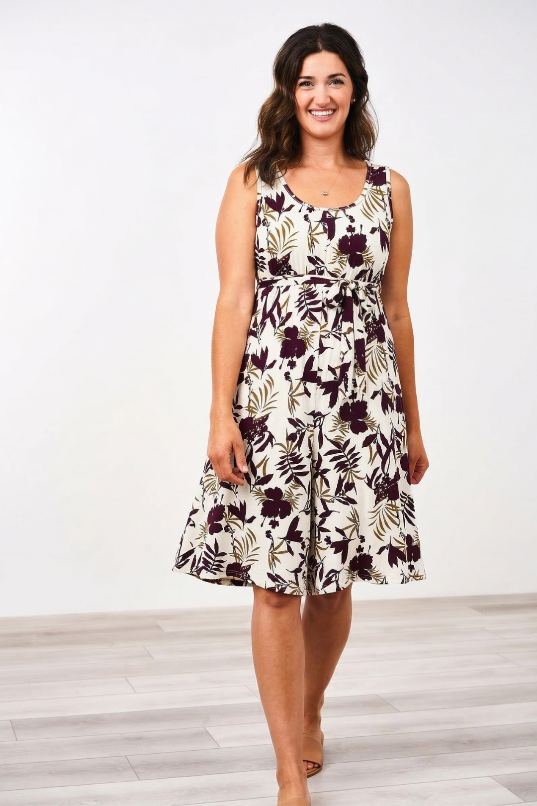 Woman wearing the Latched Mama Momper floral nursing romper on a white background
