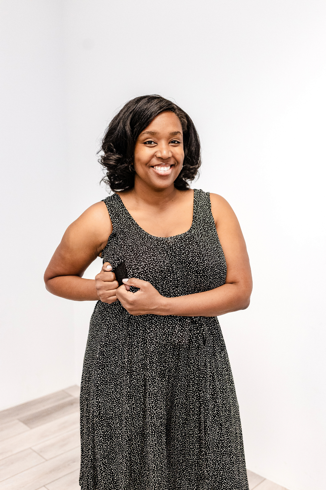 Woman wearing a sky scatter Latched Mama printed nursing Romper Momper and showing the side nursing access.