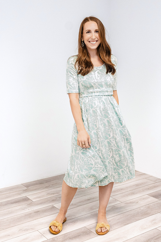 Woman wearing a latched mama classic cotton nursing dress with brown sandals.