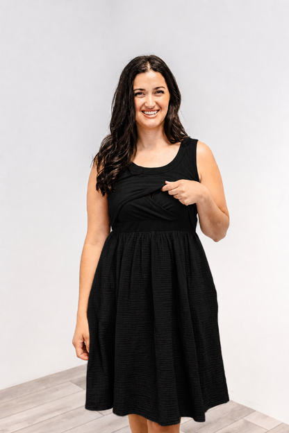 Woman showing the lift-up v-neck nursing access on the Latched Mama Breezy Cotton Nursing Dress in black.