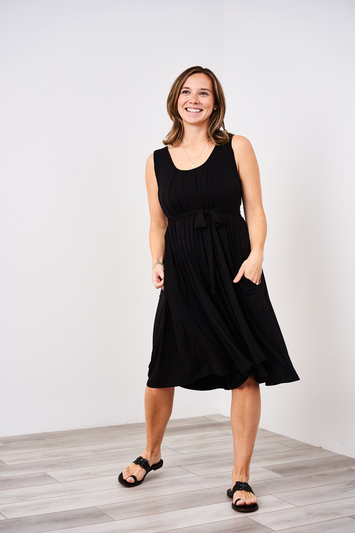 woman wearing a tank style latched mama nursing romper momper in black.