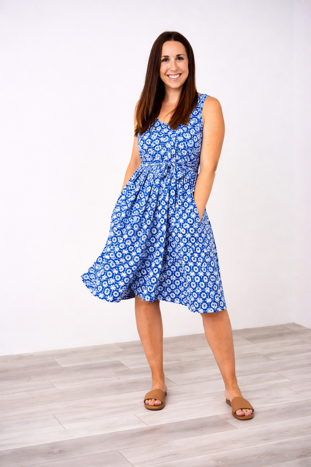 Woman wearing a blue floral Latched Mama nursing romper standing against a white background