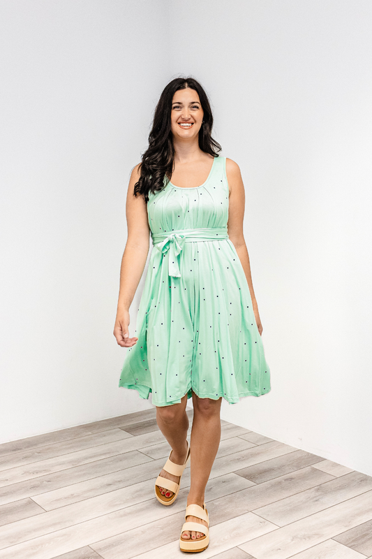 Woman wearing a polka dot "harbor mist" Latched Mama nursing romper momper with white sandals.