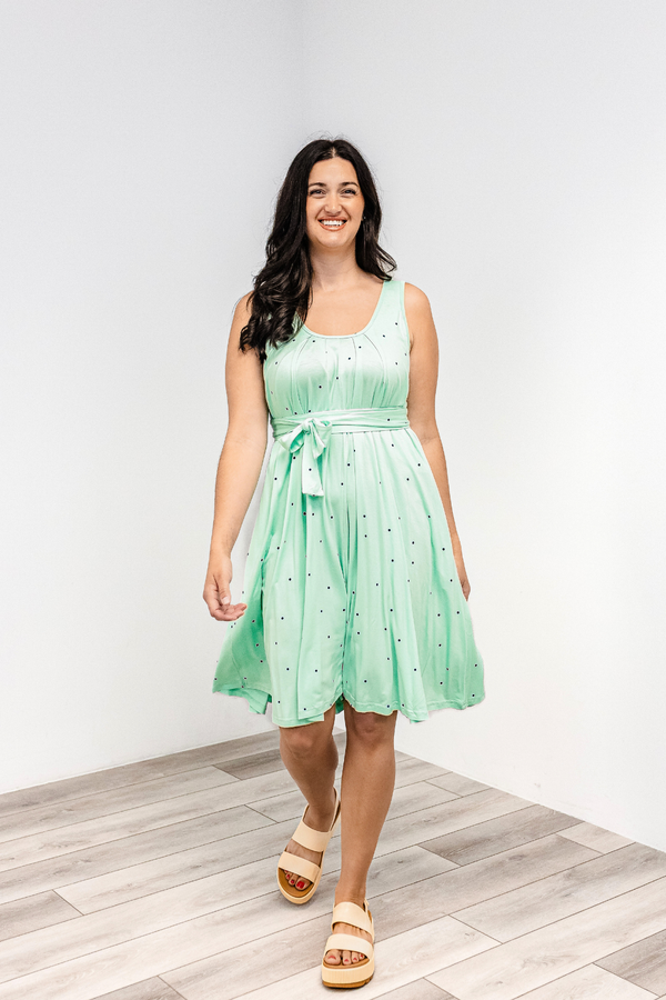 Woman wearing a polka dot "harbor mist" Latched Mama nursing romper momper with white sandals.