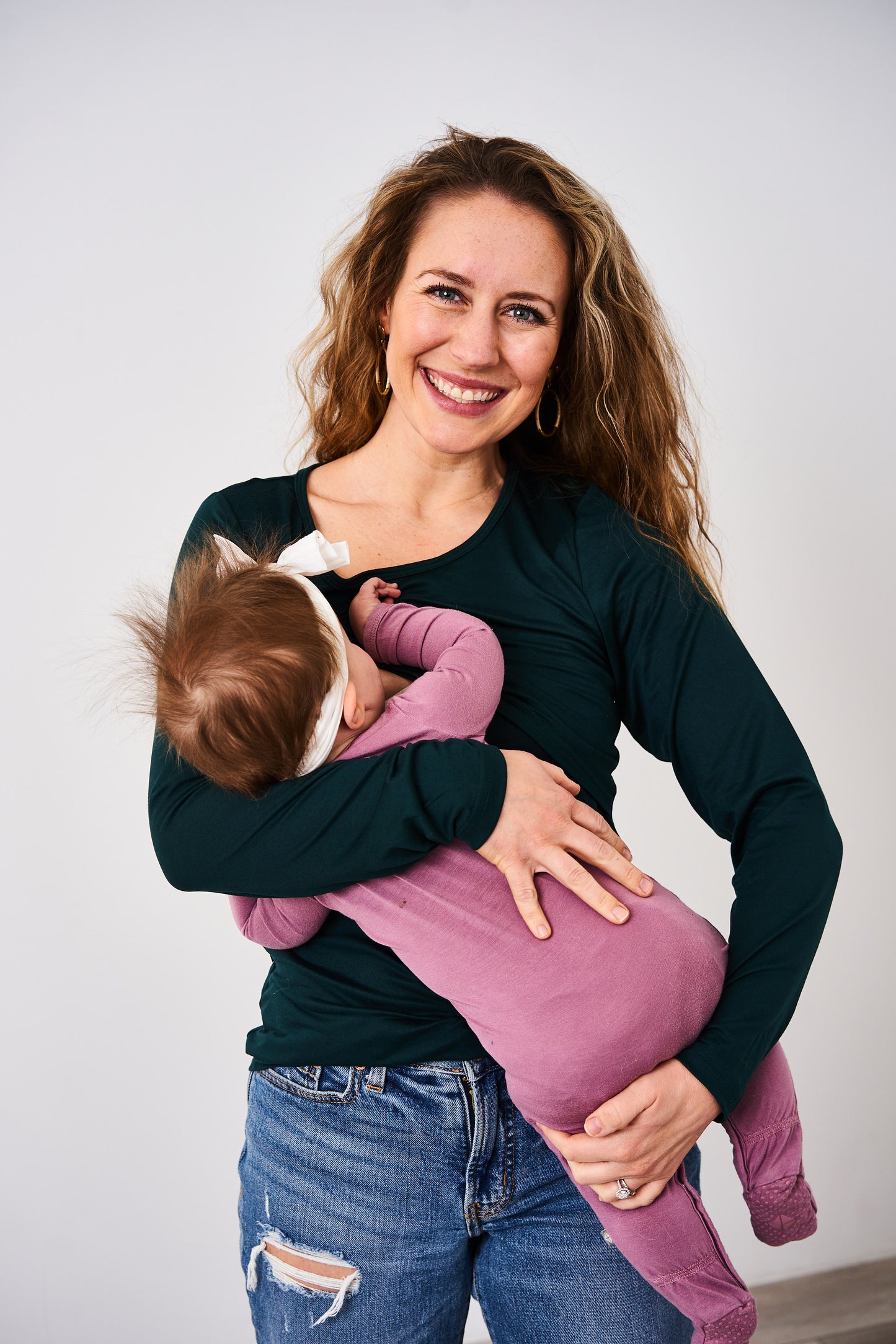 Women breastfeeding a baby in a long sleeve nursing green shirt