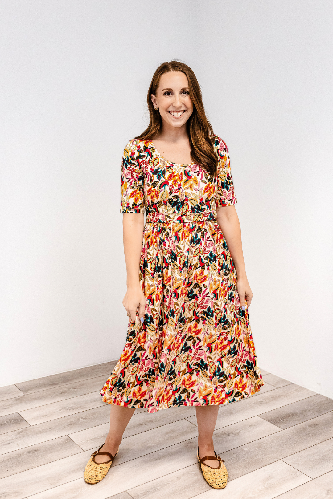 Woman wearing a latched mama classic cotton nursing dress in wildberry aviary on a white background
