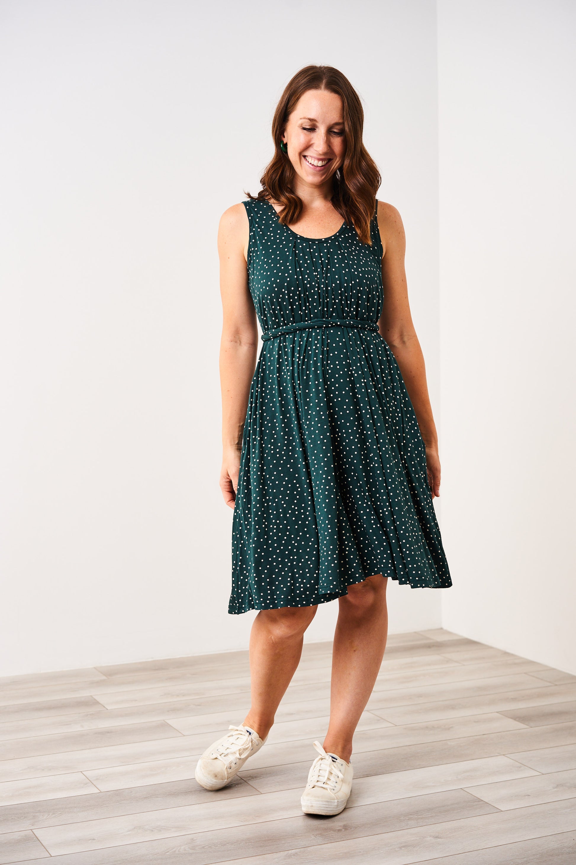 Woman wearing a Latched Mama Nursing Romper Momper in Forest Green Dot with a white background