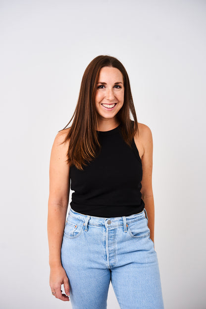 Woman wearing a Latched Mama black high neck nursing tank on a white background.