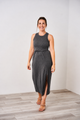 Woman wearing a Latched Mama dark charcoal nursing midi slit dress on a white background.