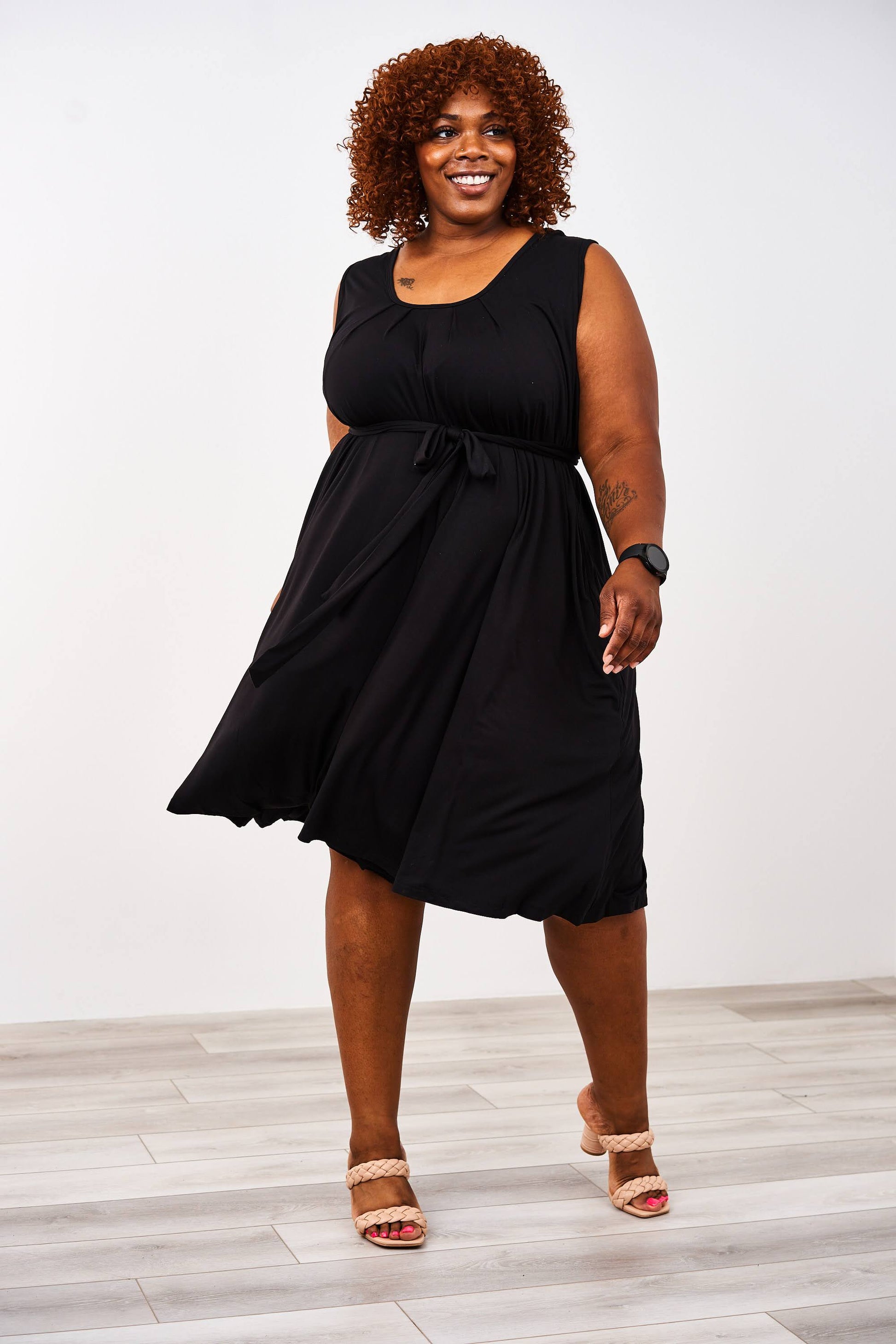 woman wearing a black latched mama nursing romper momper with beige heels