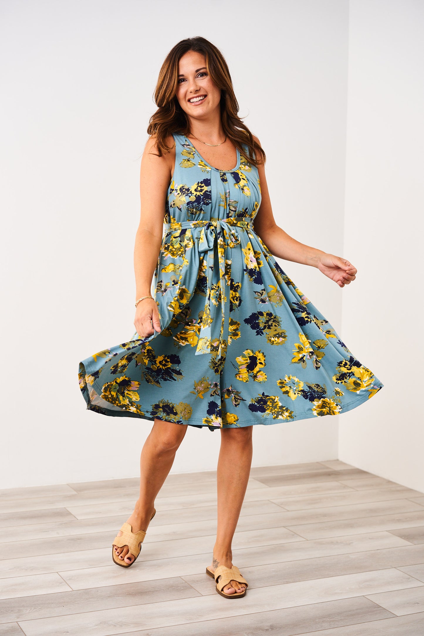 Woman wearing a Latched Mama nursing romper with yellow flowers on a white background