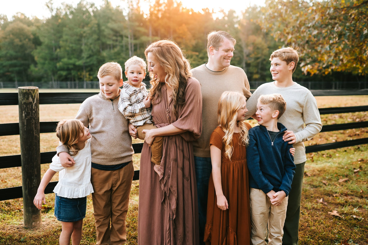 Melissa and Eric sharing a relaxed moment with their six children on the farm