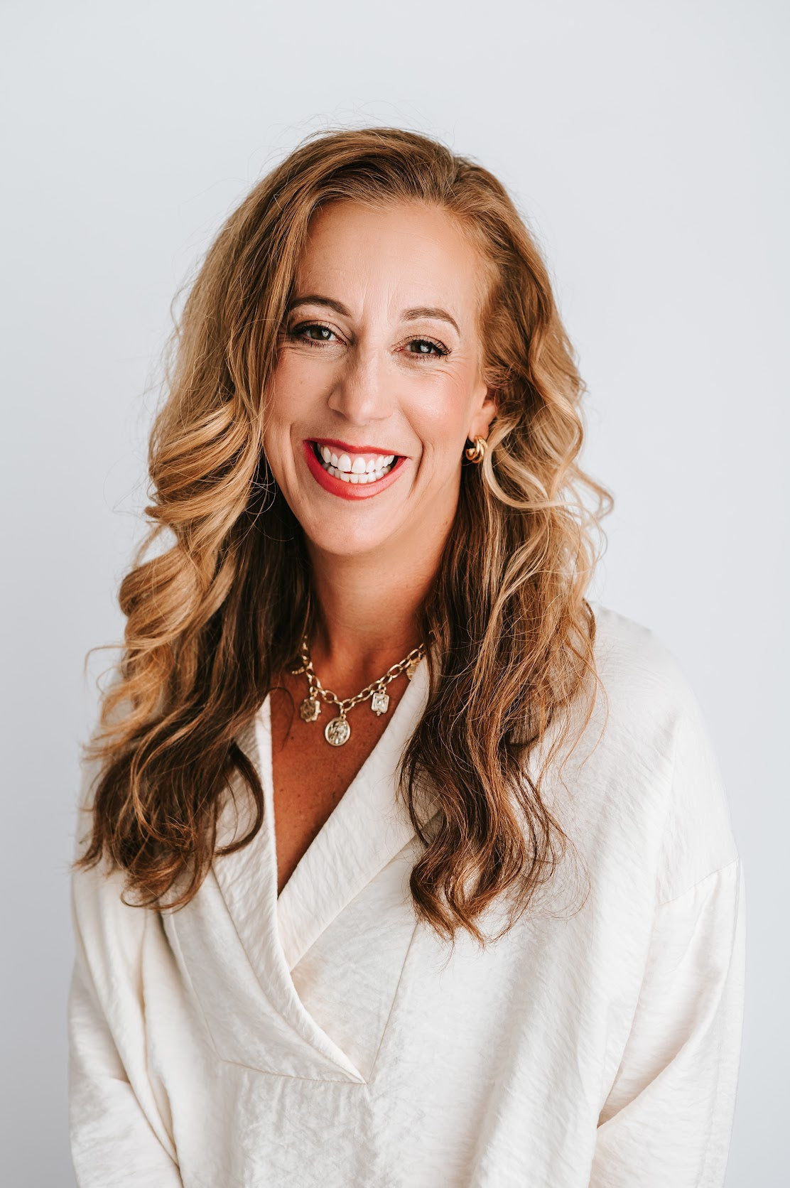 Melissa Wirt smiling in a white blouse, photographed in 2024