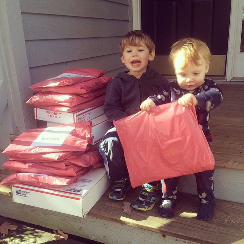 A little helper holding an early Latched Mama package
