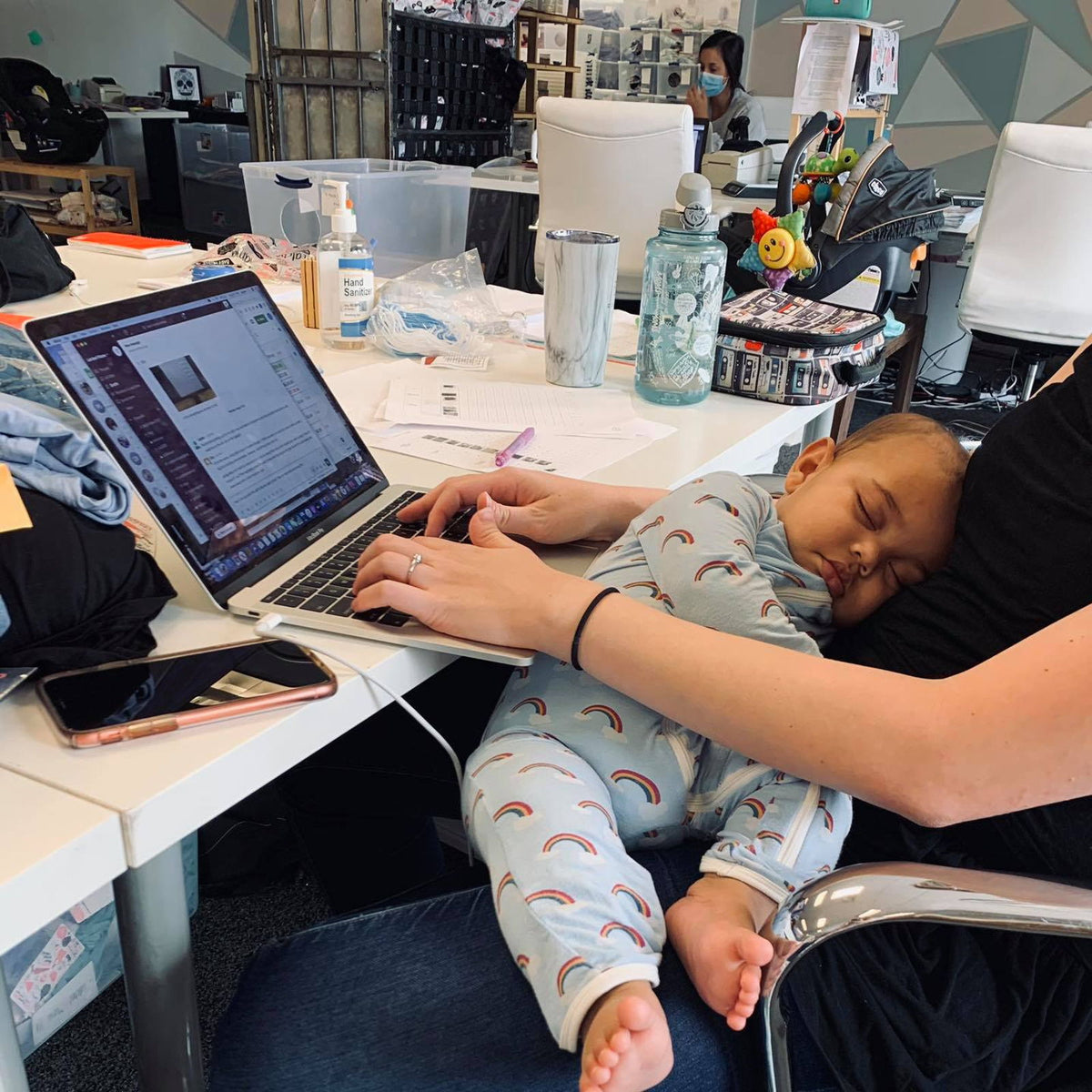 A Latched Mama team member working with her baby beside her during the warehouse years