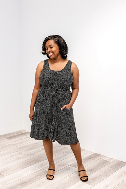 Woman wearing a latched mama printed nursing momper romper with white polka dots.