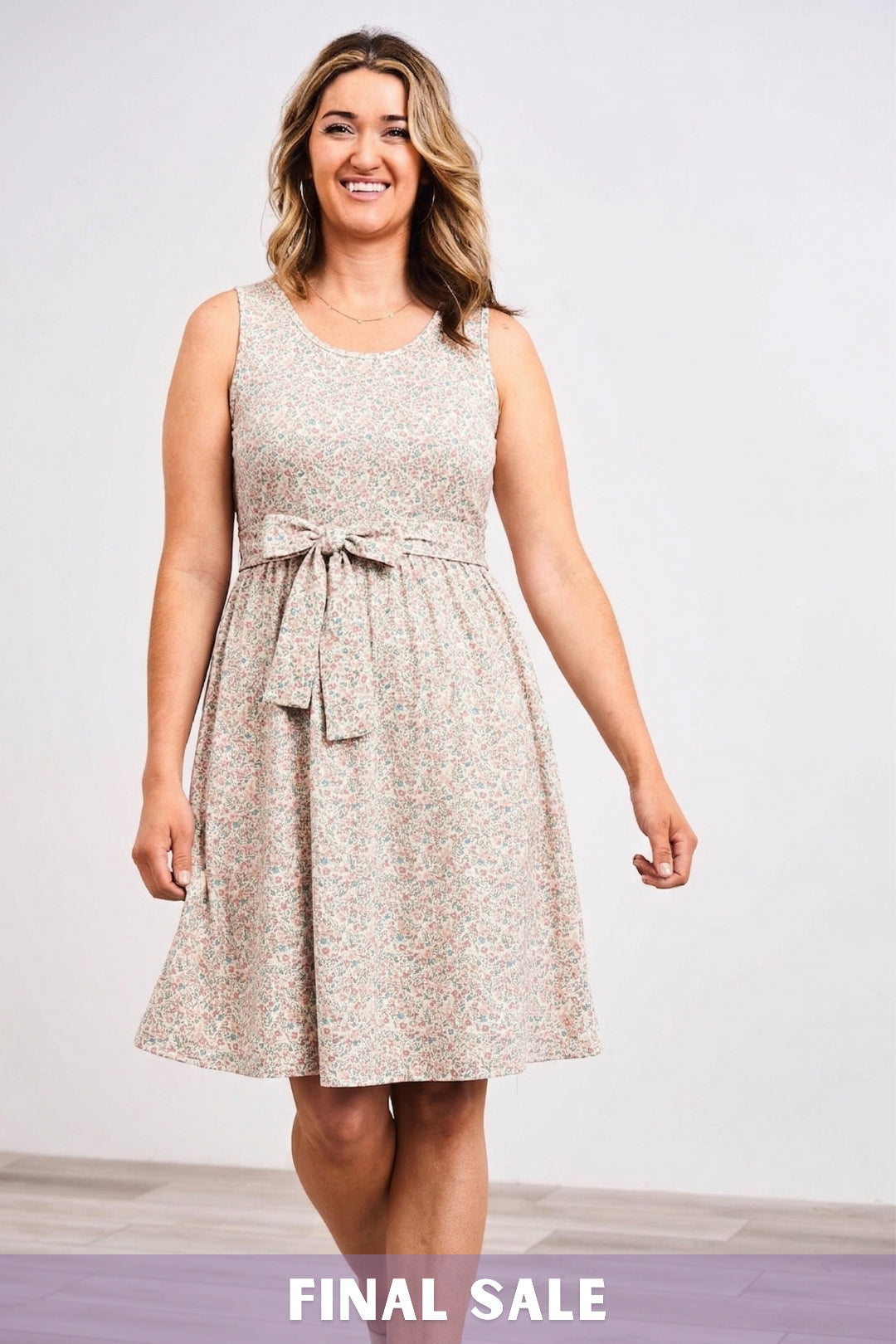Woman wearing a sleeveless Latched Mama belted nursing dress against a white background