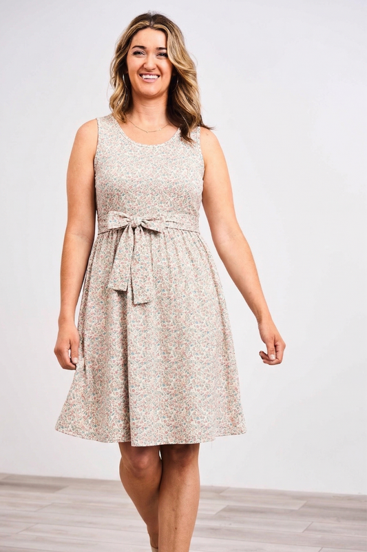 Woman wearing a sleeveless Latched Mama belted nursing dress against a white background